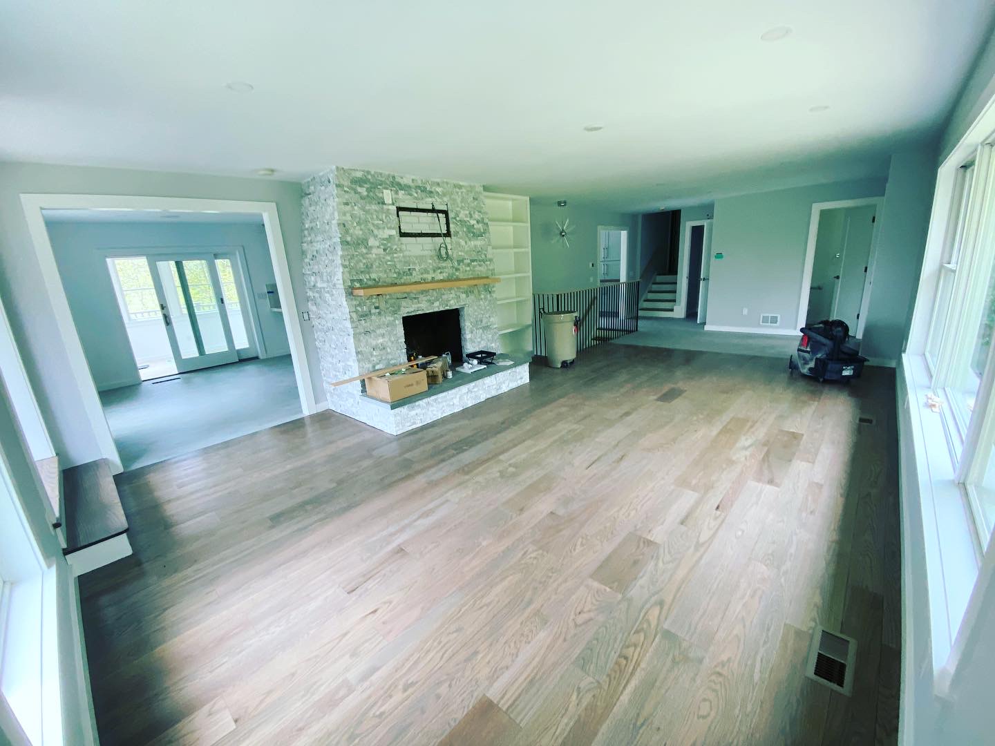 Repainted living room with stone fireplace and refinished hardwood floors